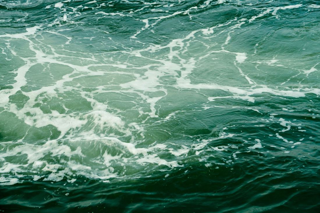 Deep green ocean water with white foam, no shore in view